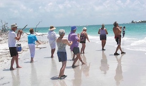 people doing tai chi on the beach