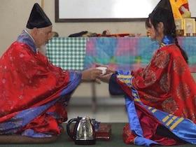 two people sitting sharing tea